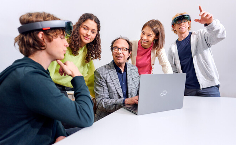  En grupp människor runt ett bord med en bärbar dator