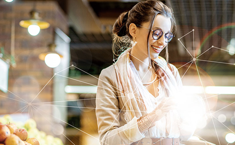 마트에서 휴대전화를 바라보며 웃고 있는 여성