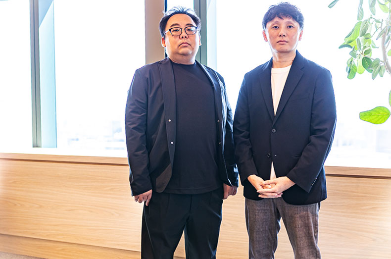 窓際で立つ内田 茂樹 氏と今井 悟史