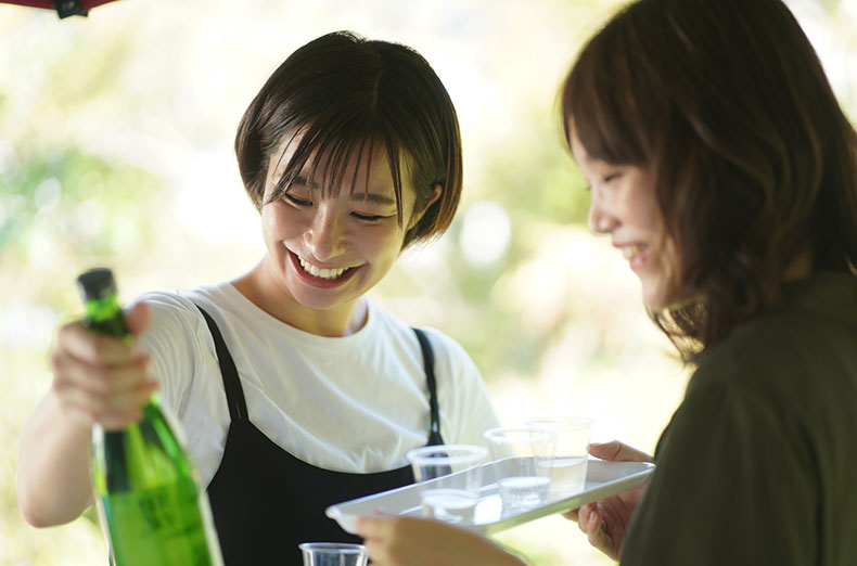 女性が楽しそうに、商品であるお酒を見比べている