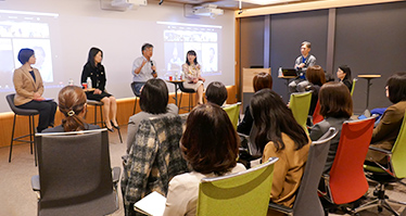 時田社長とその他執行役員が登壇し、話をしている。また熱心に話を聞く参加者も写っている。