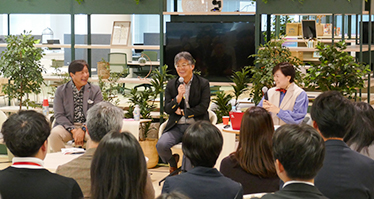 時田社長と大西執行役員が登壇し、楽しそうに談笑している写真