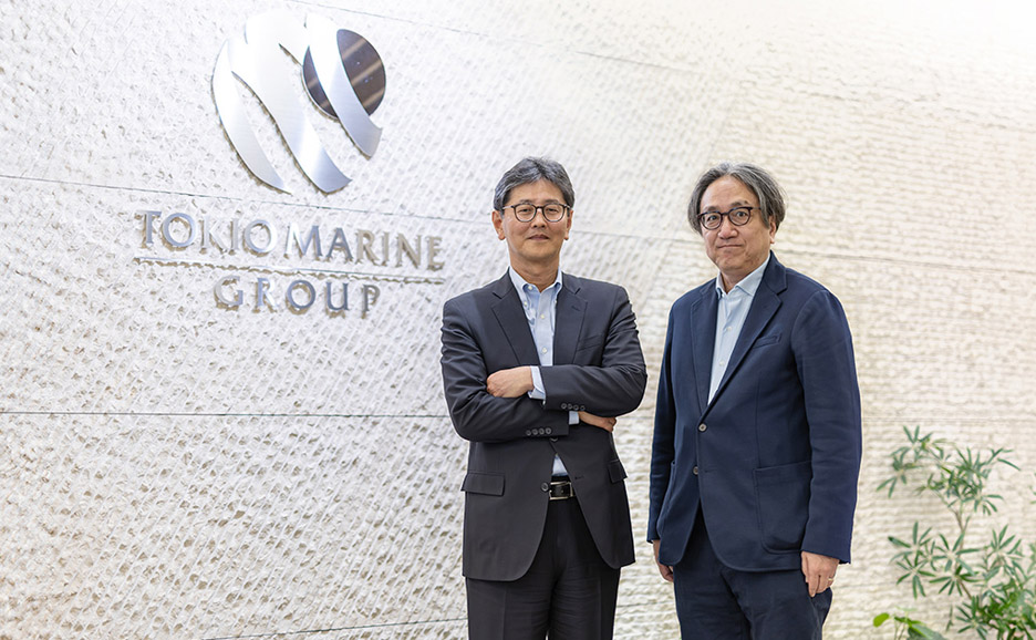 東京海上グループのロゴ前でポーズを取る東京海上日動火災保険株式会社様と東京海上レジリエンス株式会社様