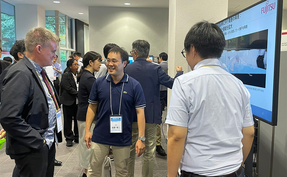 研究成果について説明を行う研究員と聞き入っている教授