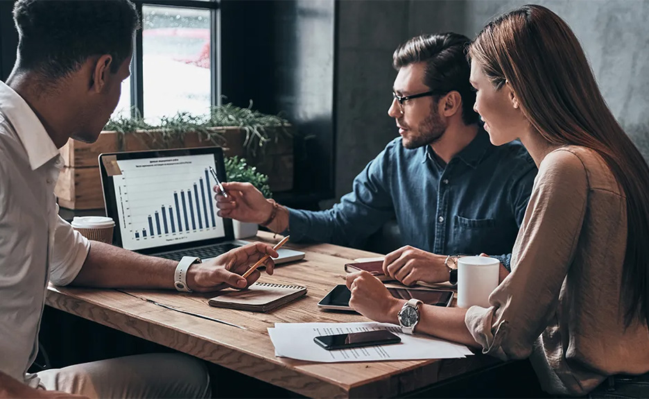 Diverse Gruppe junger Geschäftsleute, die im Büro gemeinsam Daten am Computer analysieren