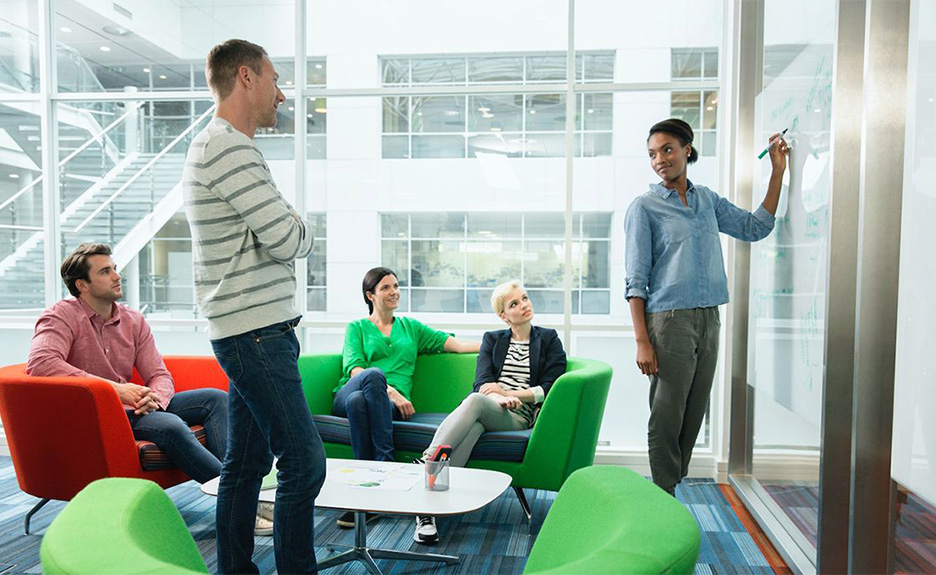 Team diskutiert Ideen in modernem Büro vor einem Whiteboard.