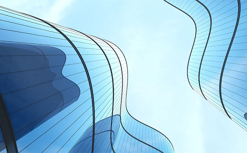 Aufnahme von unten eines futuristischen Glasgebäudes