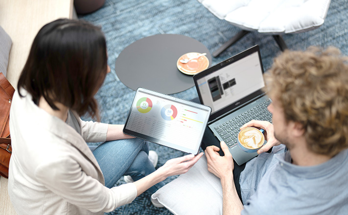 テーブルの隣に座って仕事をする2人。