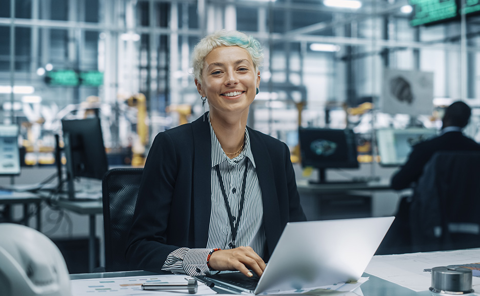 現代的なオフィスでノートパソコンを使用する女性エンジニア。