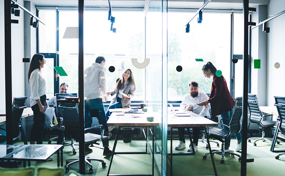 ガラス張りのオフィスで仕事をする人々のグループ。