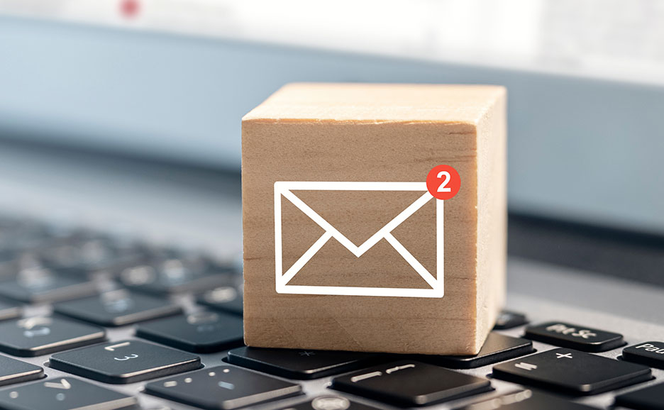 キーボードの上に置かれた木製のブロック。メールと通知が2件表示されている。