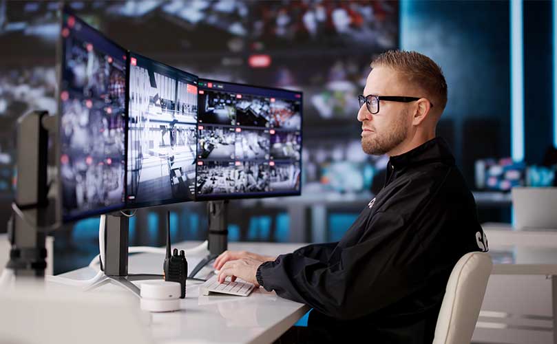 動画のモニタリングと制御のために複数のCCTV画面を監視するセキュリティ担当者