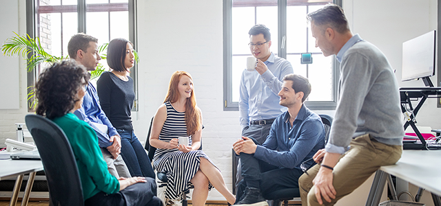 腰かけて向かい合い、和やかに話す男女グループ