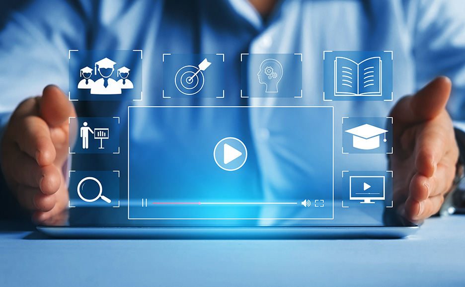 タブレットに再生ボタンとeラーニングアイコンが表示されている。