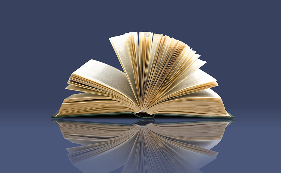 開かれた本のページが暗い青い背景に広がり、平らな面に反射しています。