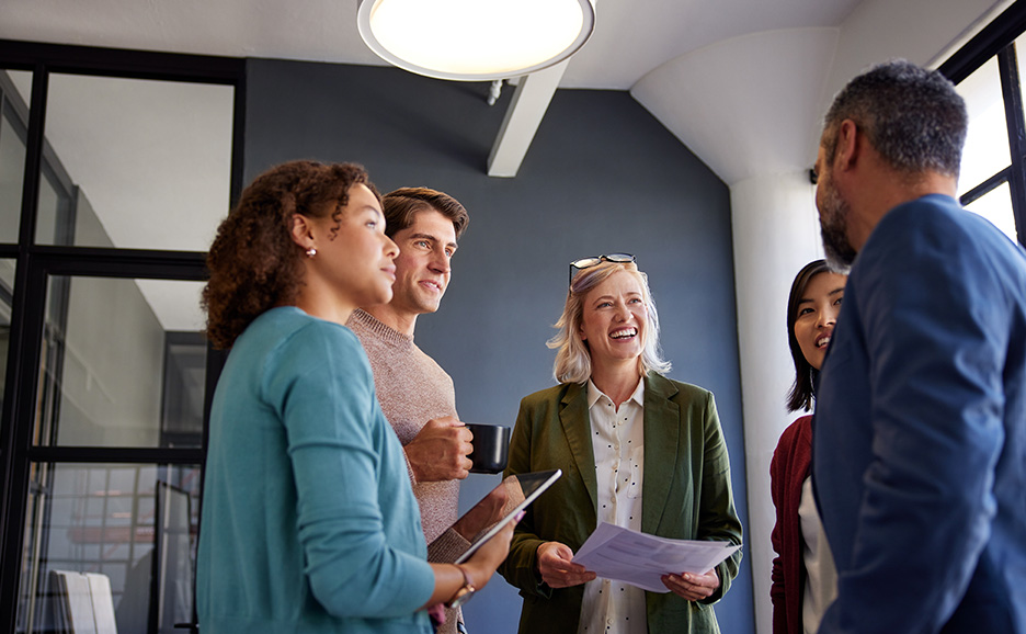 オフィスで笑顔で話すビジネスパーソンたち