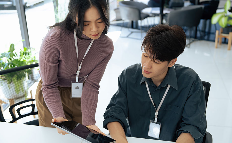 デバイスを見ながら会話する男女