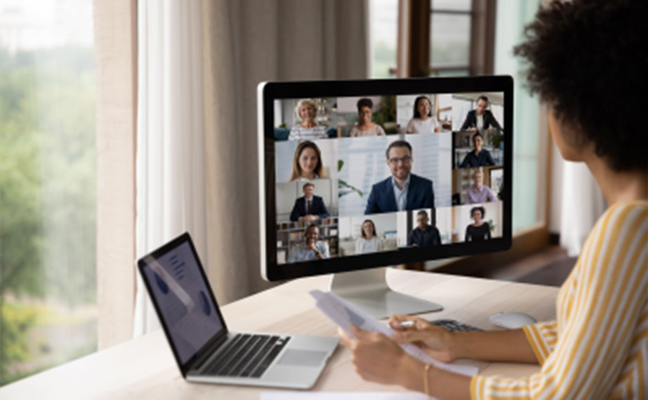 パソコンのモニタに映る大勢とリモート会議をしている女性