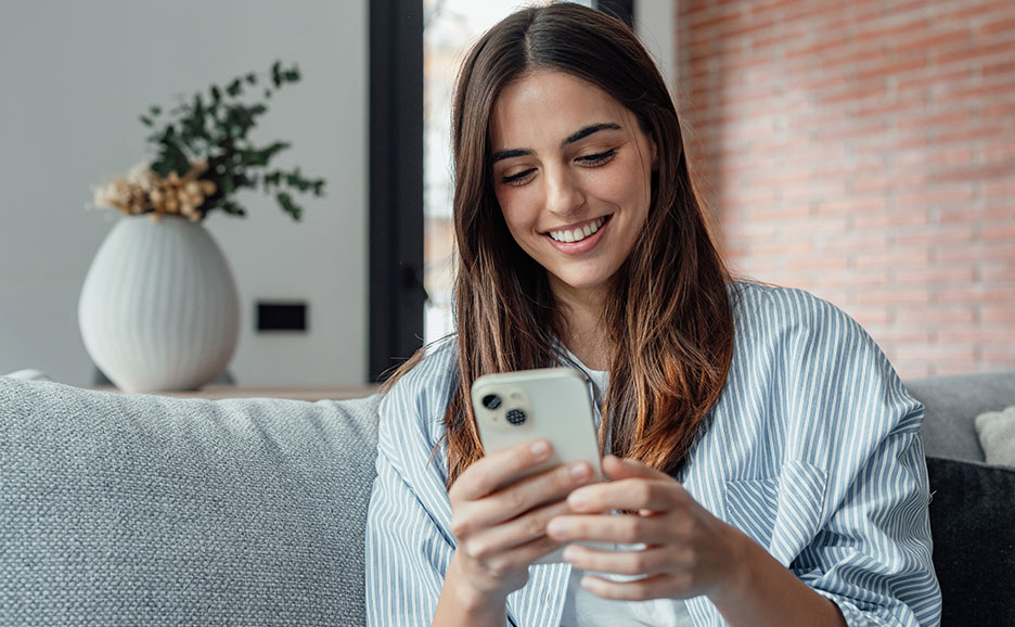 A woman operating her smartphone at home