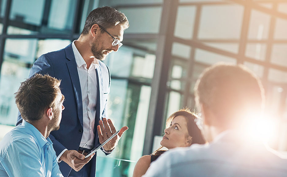 会議室で議論する4人のプロジェクトメンバー