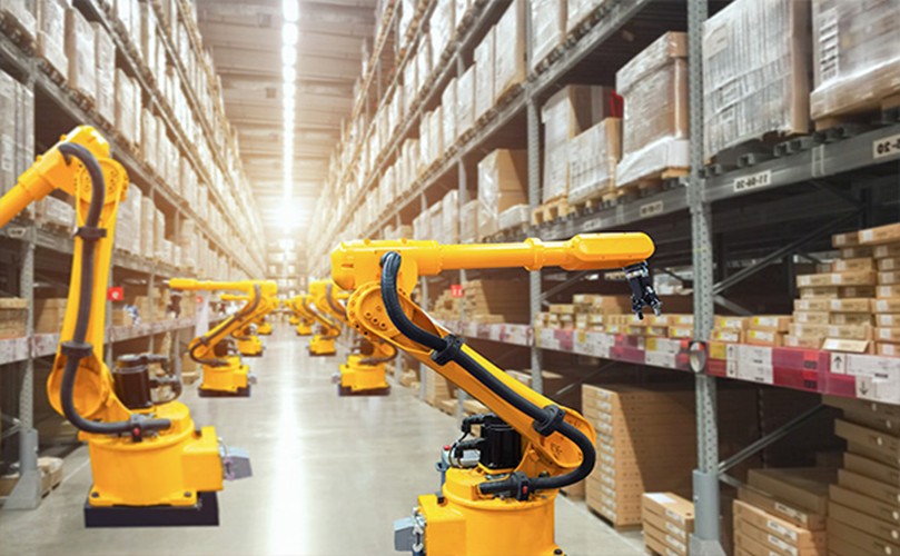 Robots navigate a warehouse filled with boxes and shelves, showcasing automated logistics in action.