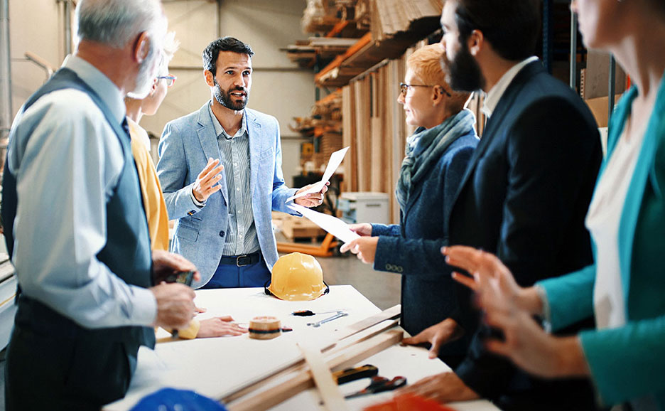 一人が説明を行い、残りの4人が熱心に聞き入る会議風景