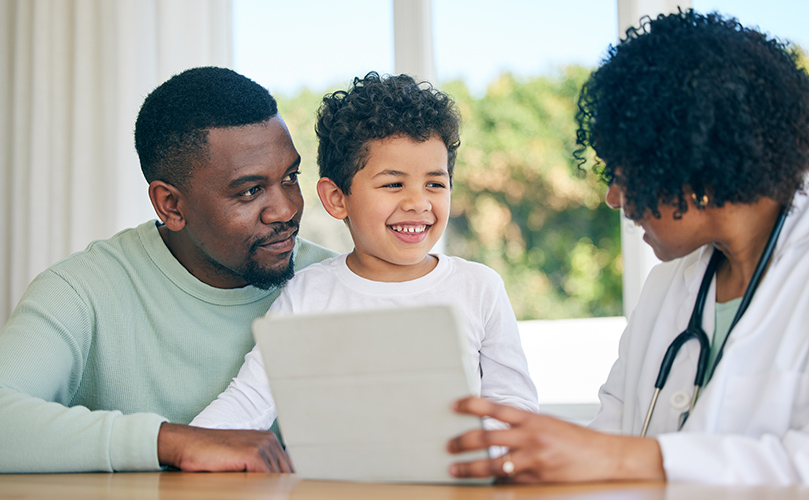 A man and a woman examine a tablet, appearing to discuss its content.