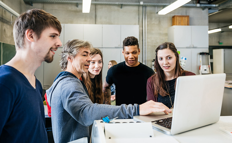 Images of several technicians talking in front of a laptop