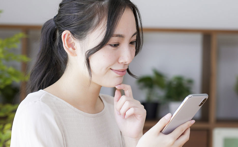 穏やかな顔でスマホを見る女性