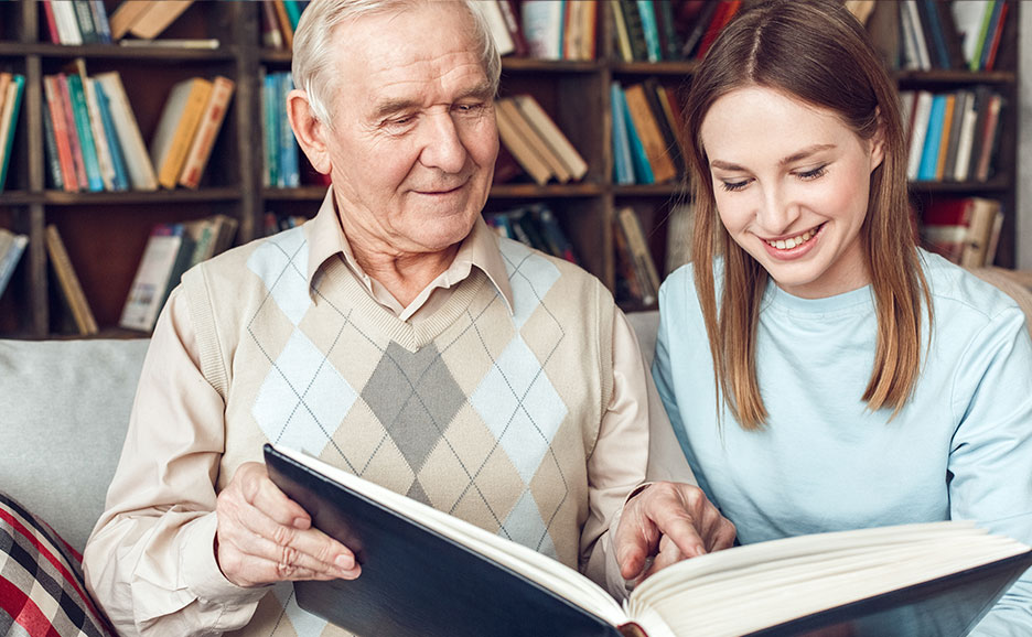 図書館で読書をする年配の男性と若い女性