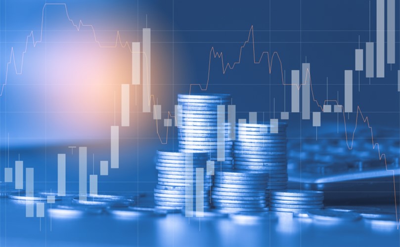 Coins and stock charts displayed on a blue background, illustrating financial trends and investments.