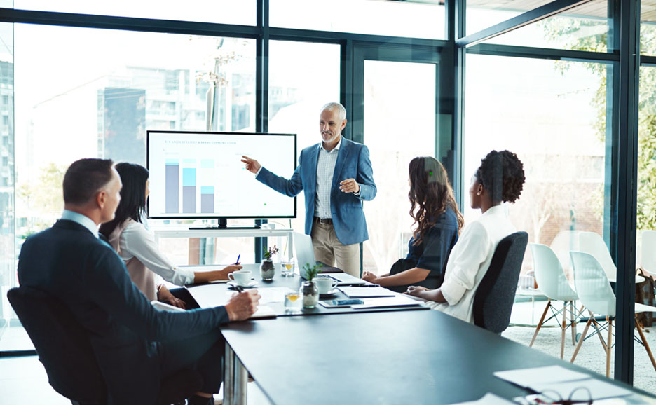 提案をするビジネスマンと話を聞く4名の男女