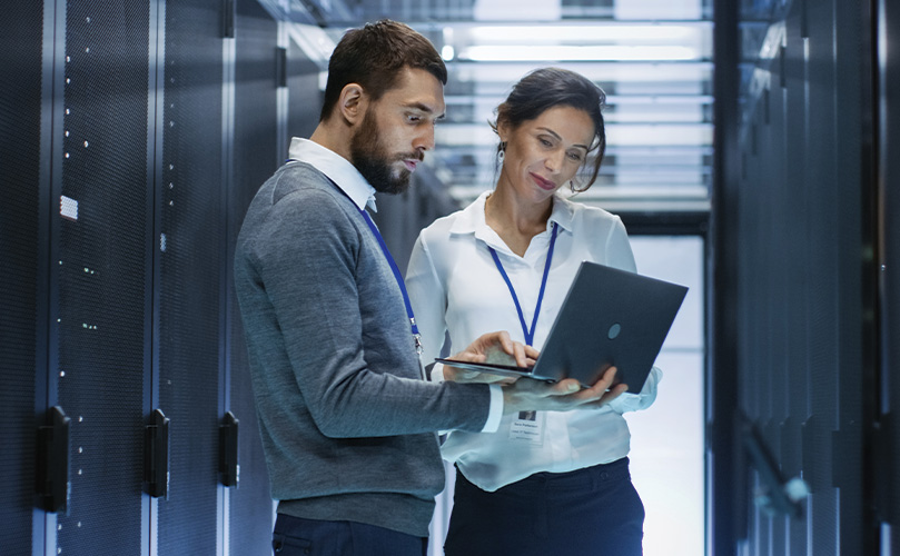 IT-Mitarbeitende besprechen Daten im Serverraum