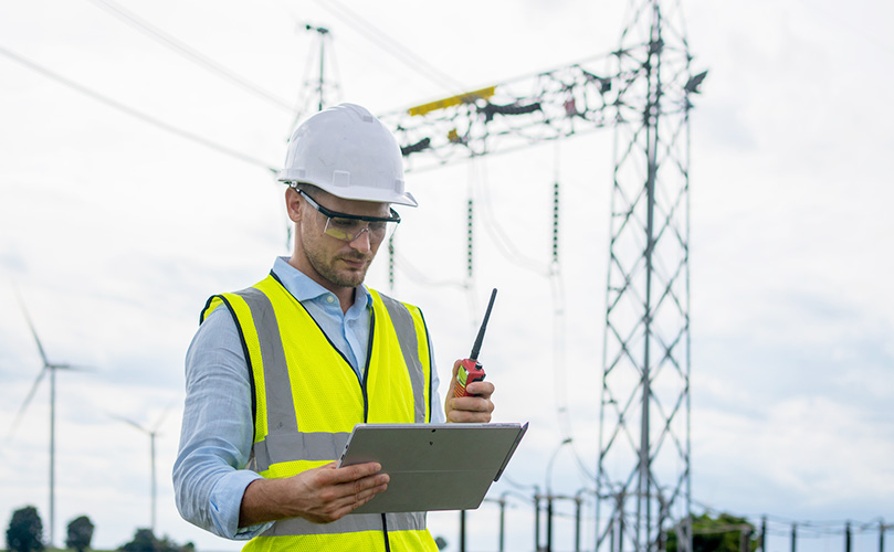 Technical engineer using laptop for maintenance in wind turbine farm