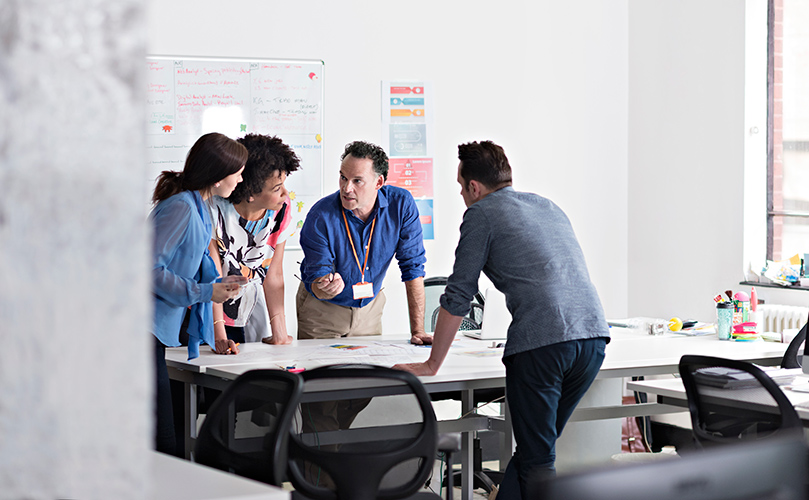 A diverse group of professionals collaborating in a modern office setting.