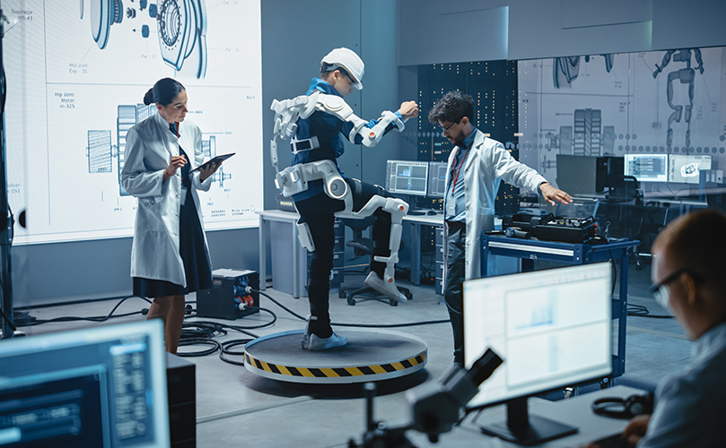 Several individuals in lab coats working together on a robot, surrounded by various tools and equipment in a lab.