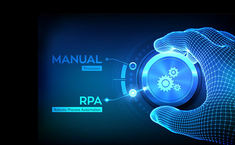 A man wearing glasses is focused on working at his computer, typing and reviewing information on the screen.