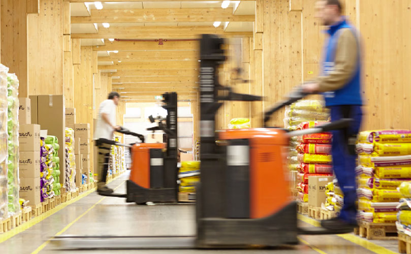 Zwei Lagerarbeiter mit Gabelstapler in der Lagerhalle	