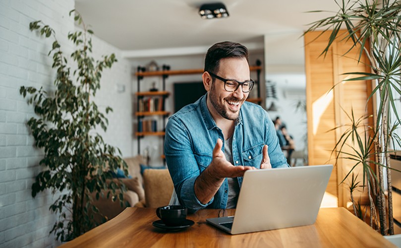 A person sitting at a table with a computer