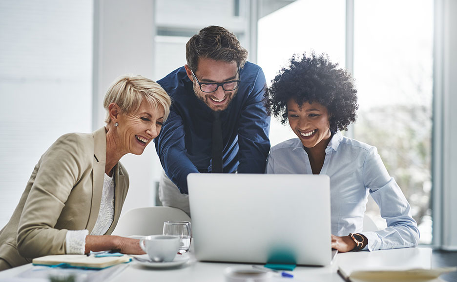 Team arbeitet gemeinsam an einem Laptop im Büro