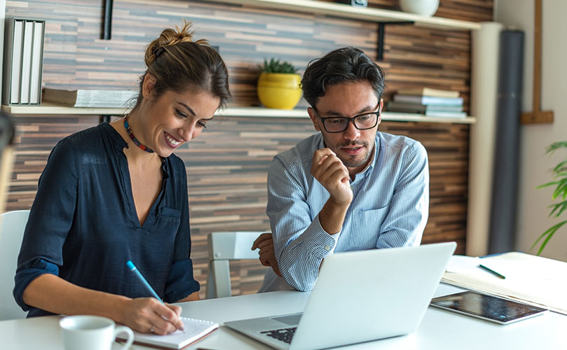 Mann und Frau arbeiten gemeinsam an einem Projekt am Laptop