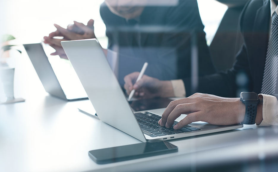 ノートPCを操作している二人の男性の手元