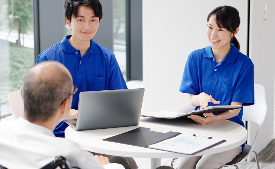 男性の話を聞いている介護スタッフ2名