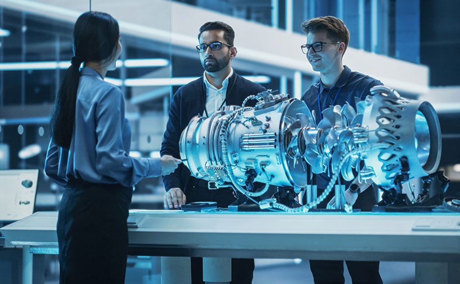 Man and woman conversing in front of engine model