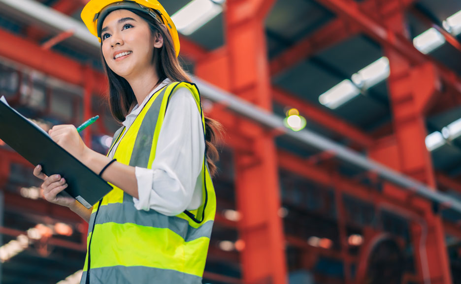 Arbeiterin macht sich in einer Fabrik Notizen