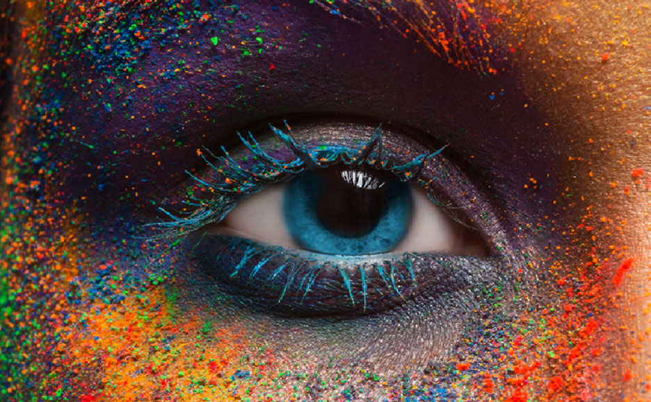 Close-up of an eye surrounded by colorful powder