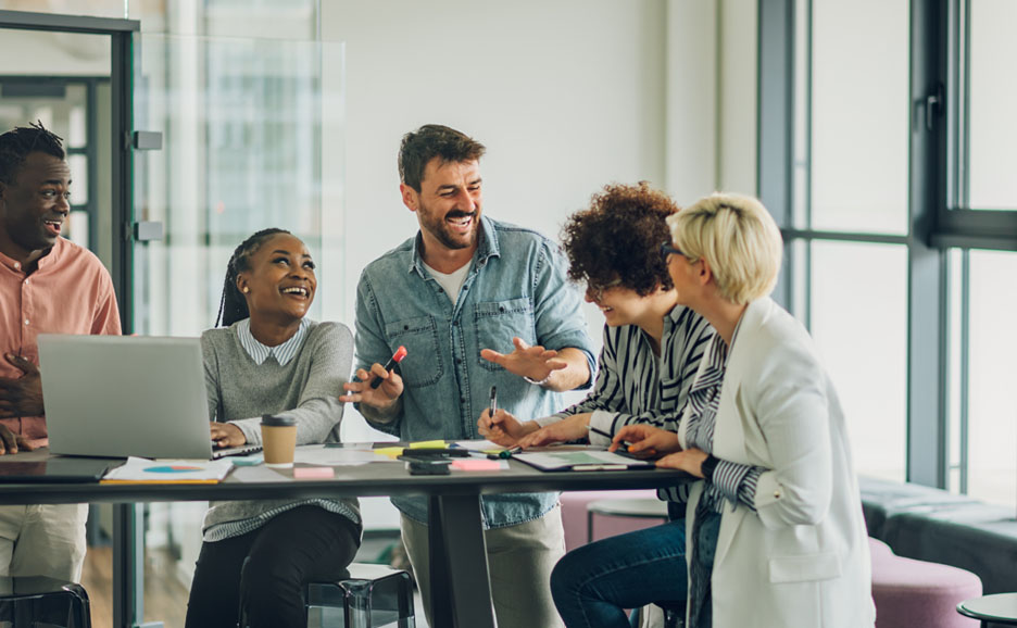Five smiling project members conversing
