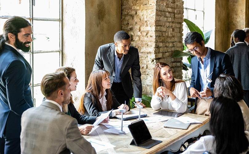 A group of business professionals collaborating around a conference table, engaged in discussion and sharing ideas.