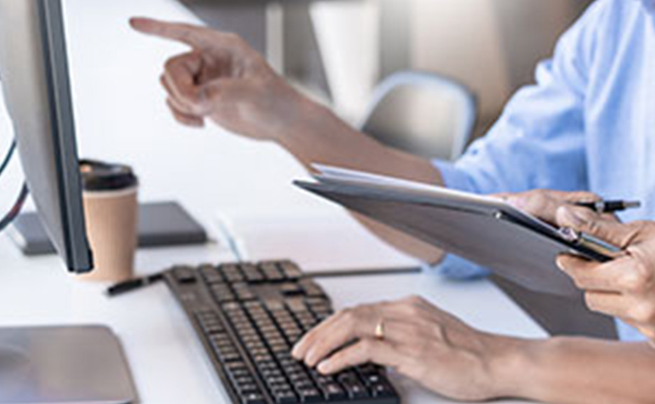 パソコン画面を指さしながら確認している2名の手元