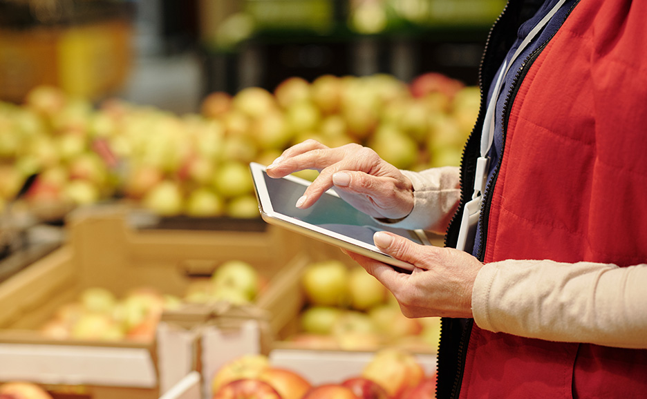青果売り場でタブレットを操作する店員の手元